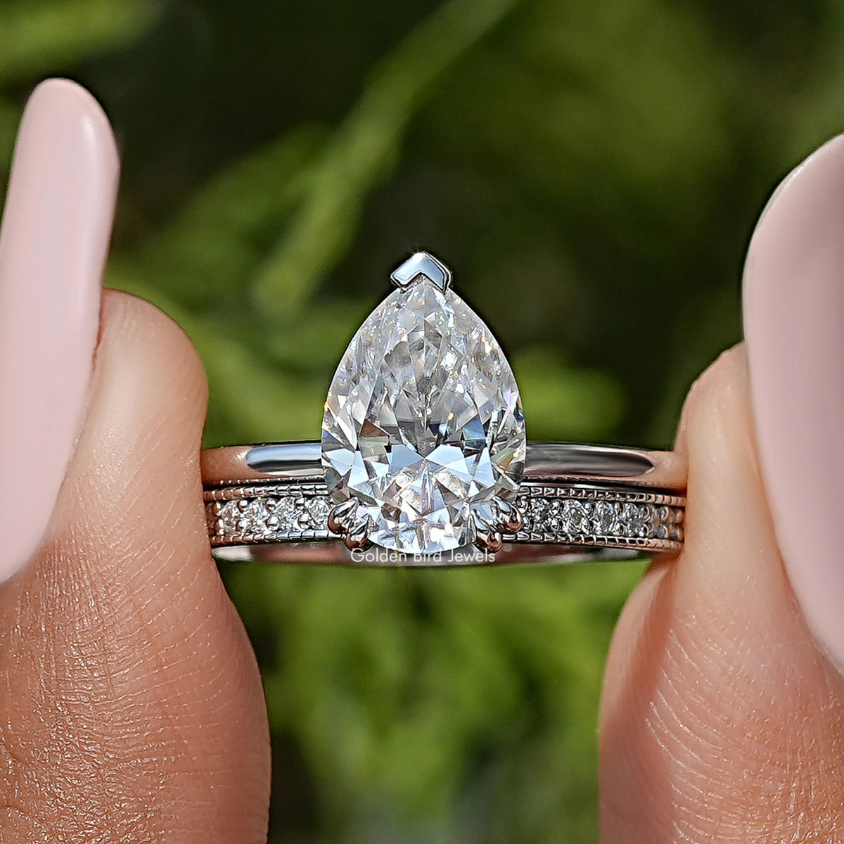 Pear moissanite ring with hidden halo and pavé eternity band, shown on a finger