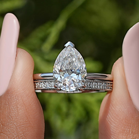Pear moissanite ring with hidden halo and pavé eternity band, shown on a finger