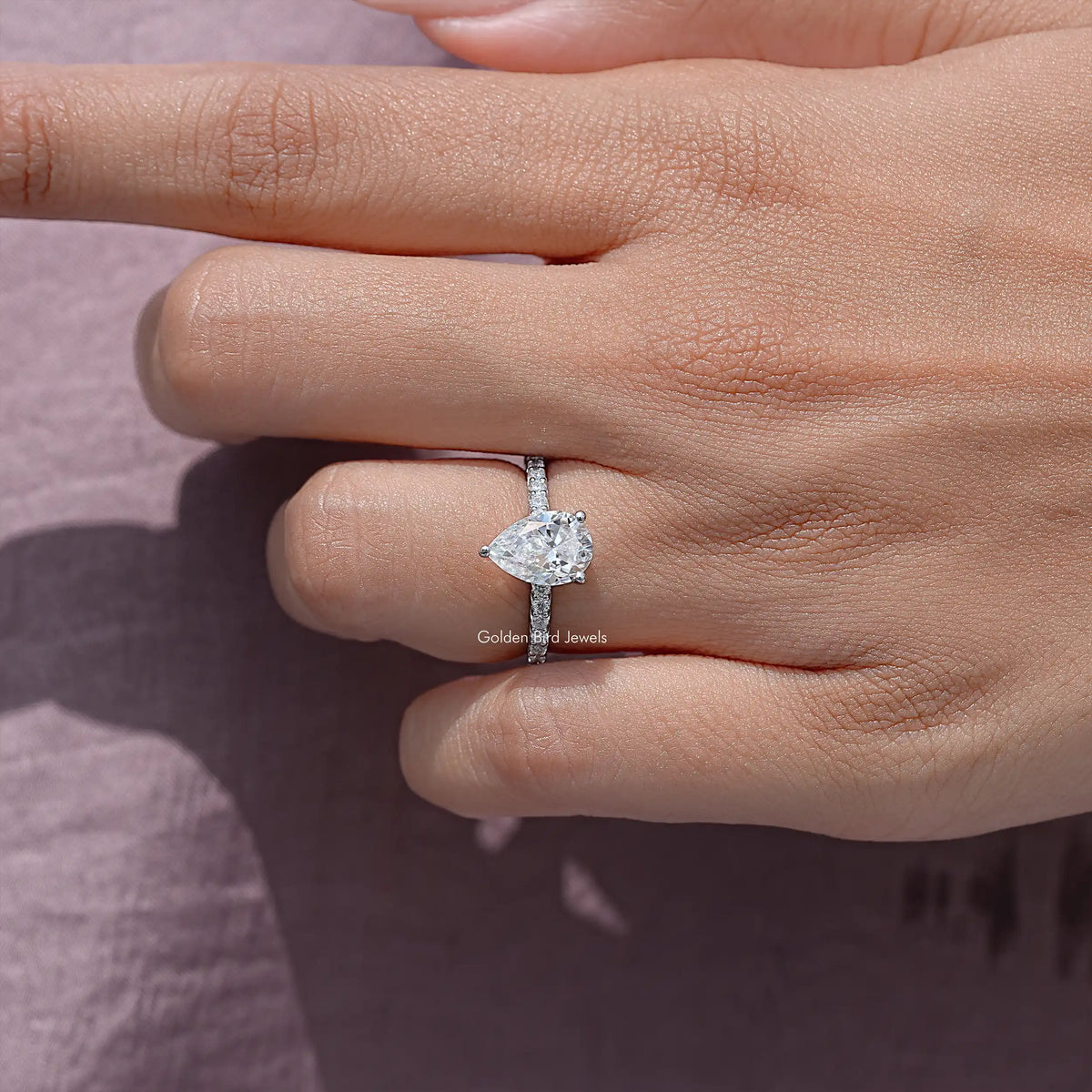 Sterling silver pear-cut moissanite solitaire ring, angled view of center stone