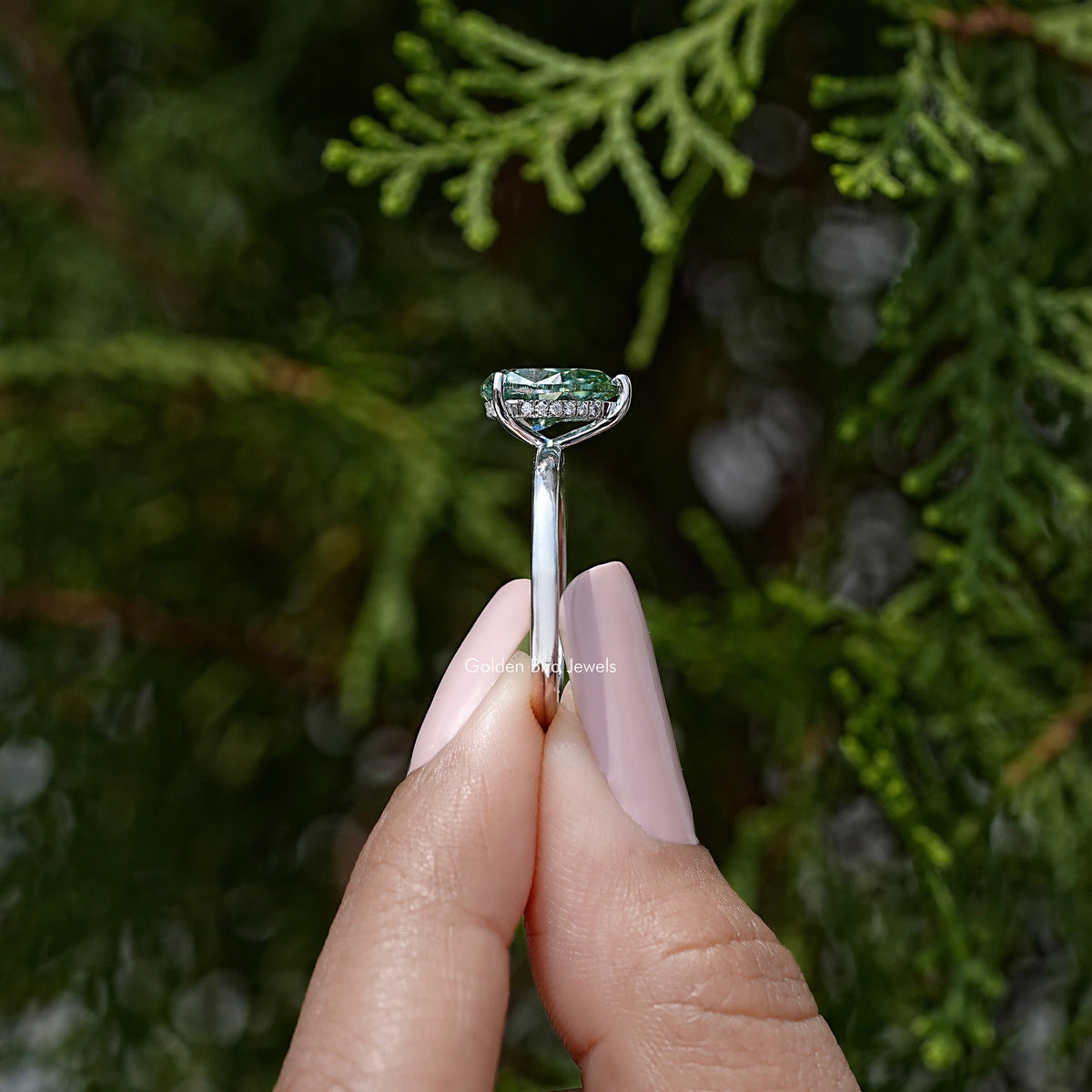 Pear-cut moissanite engagement ring with tall prong setting, green center stone
