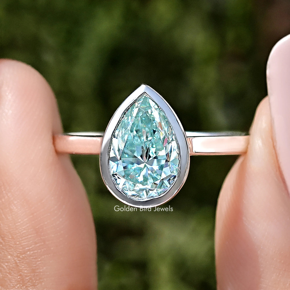Sterling silver bezel-set solitaire ring with pear-cut light blue moissanite