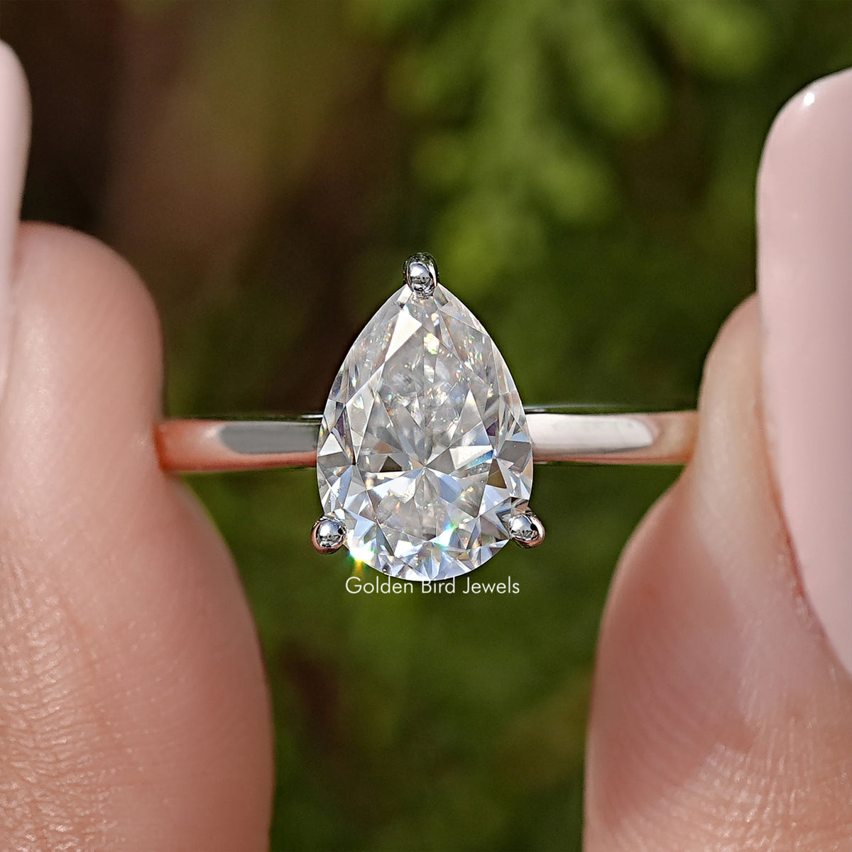 Close-up pear-cut solitaire engagement ring, clear teardrop stone with prongs, silver band