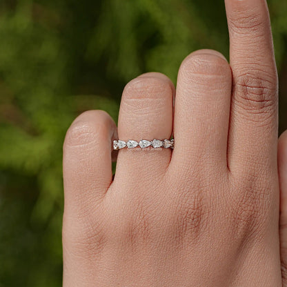 Pear-cut diamond eternity band on finger, slim silver band with stones all around