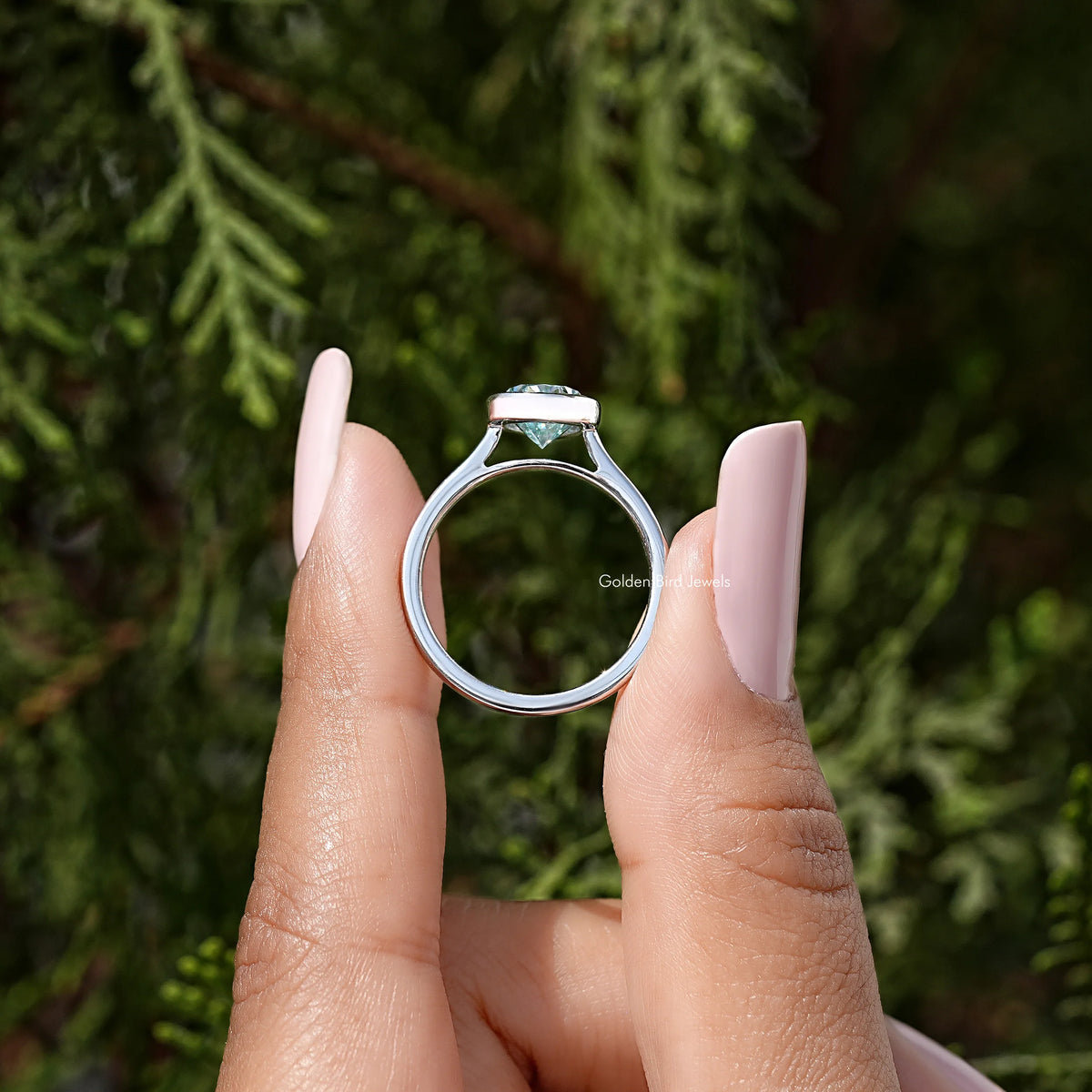 Sterling silver bezel-set solitaire ring open-angle view, pear-cut moissanite