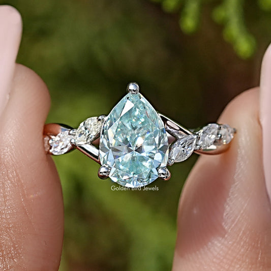 Pear-cut blue moissanite ring with floral side stones in 925 sterling silver