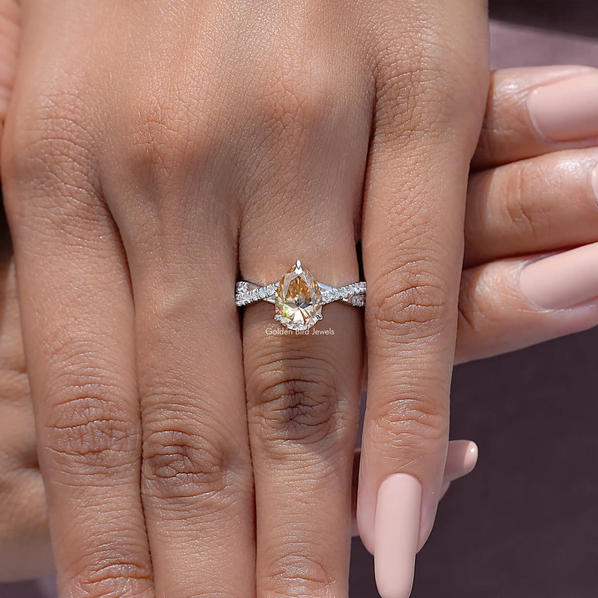 Pear moissanite twisted shank accent ring in sterling silver on a hand