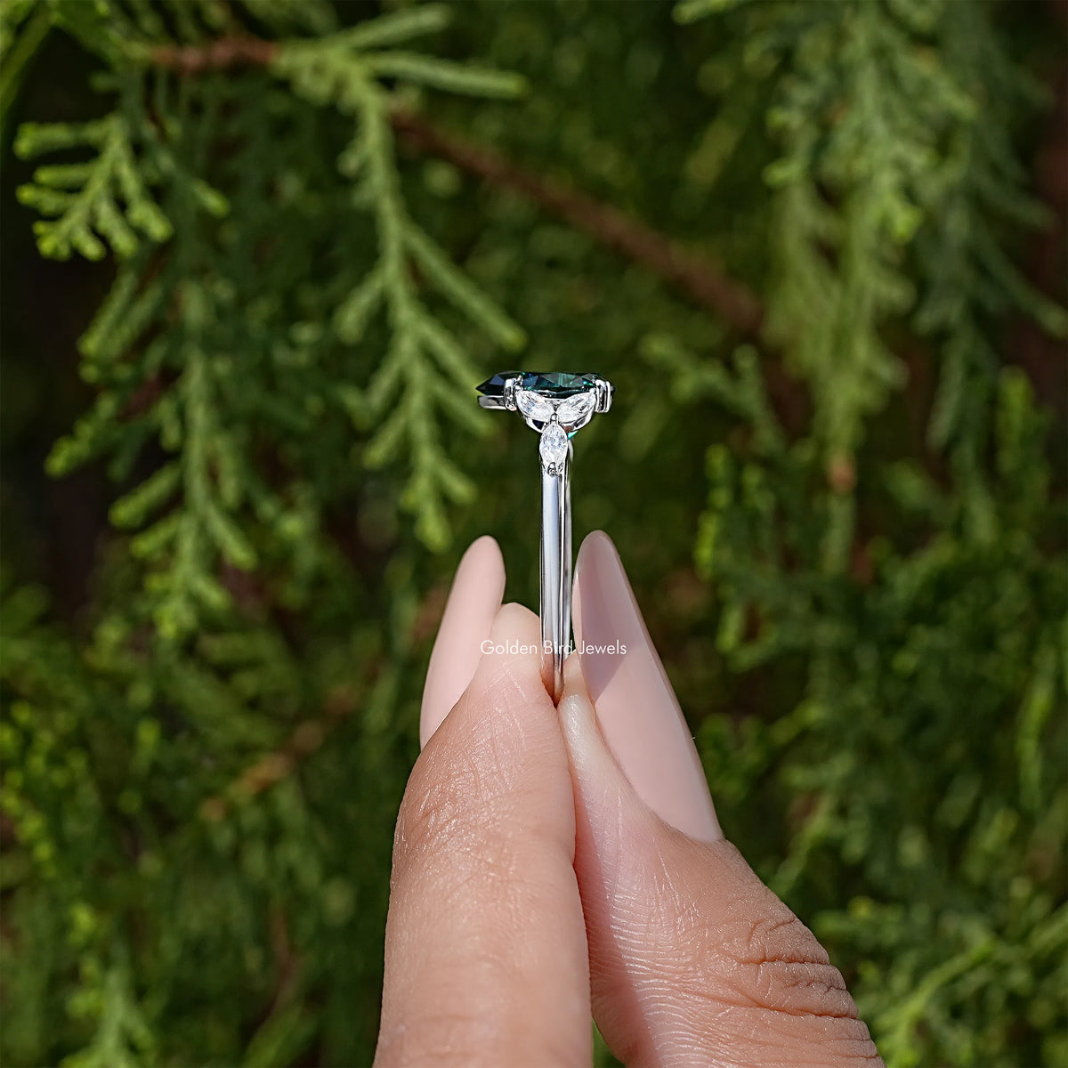 Sterling silver engagement ring with green pear-cut moissanite and diamond halo