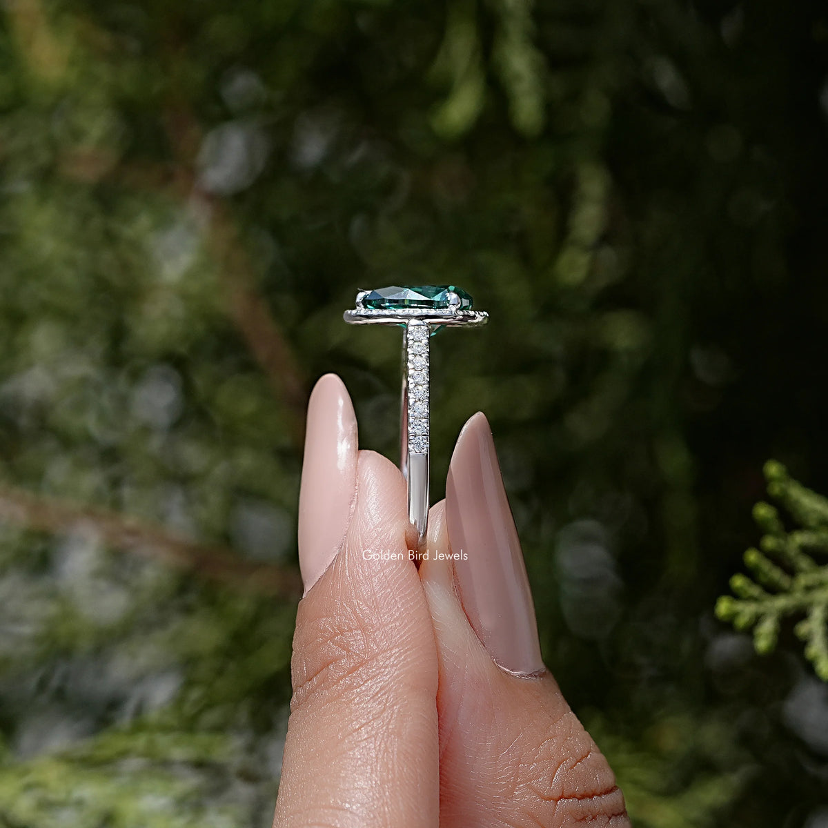Sterling silver ring top view: green pear moissanite with halo and prong set band