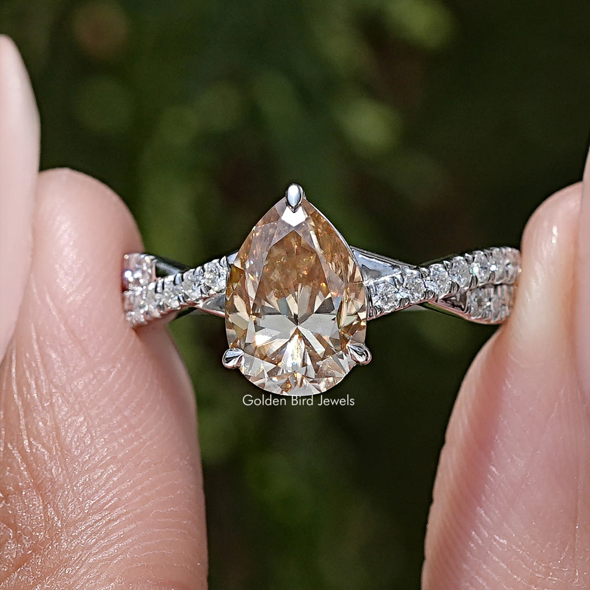 Sterling silver twisted shank ring with pear-cut moissanite center and baguette side stones