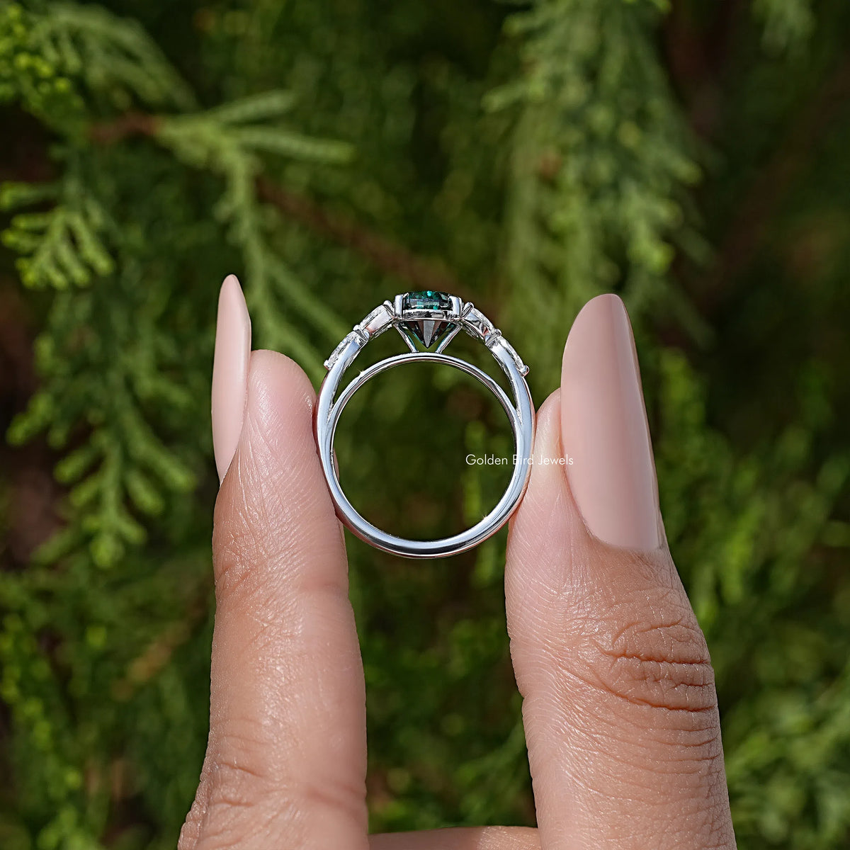 Sterling silver ring with green pear-cut moissanite center and prong-set diamond accents