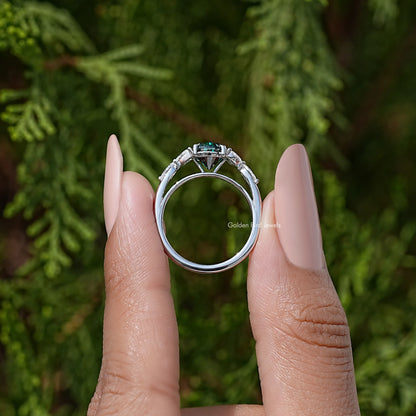 Sterling silver ring with green pear-cut moissanite center and prong-set diamond accents
