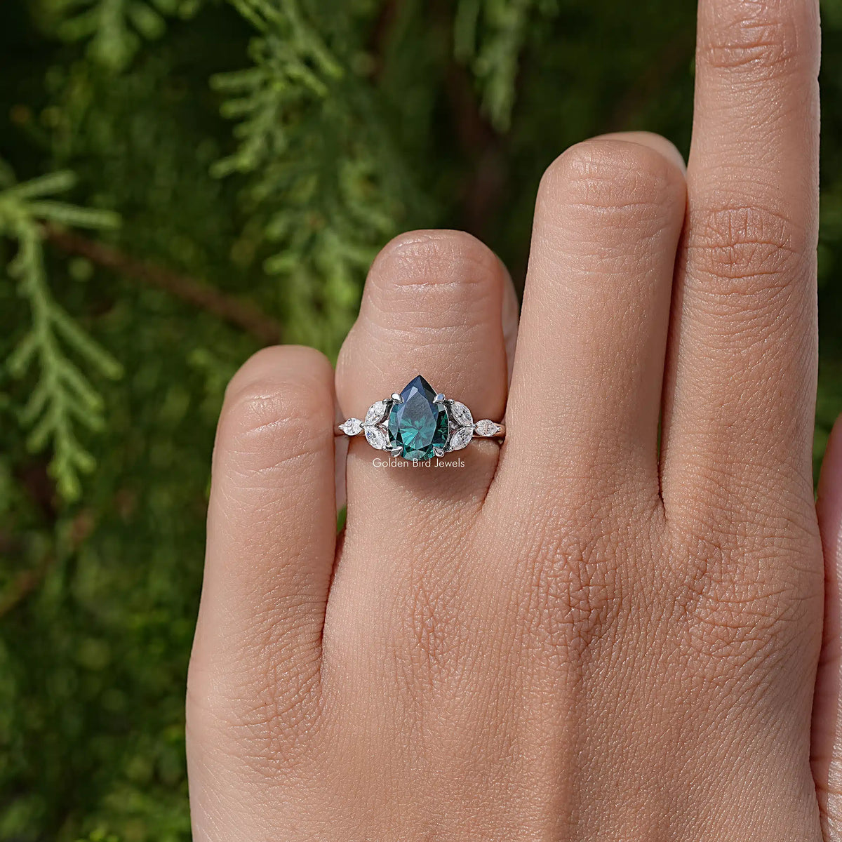 Green pear-cut moissanite engagement ring with round halo stones and side accents