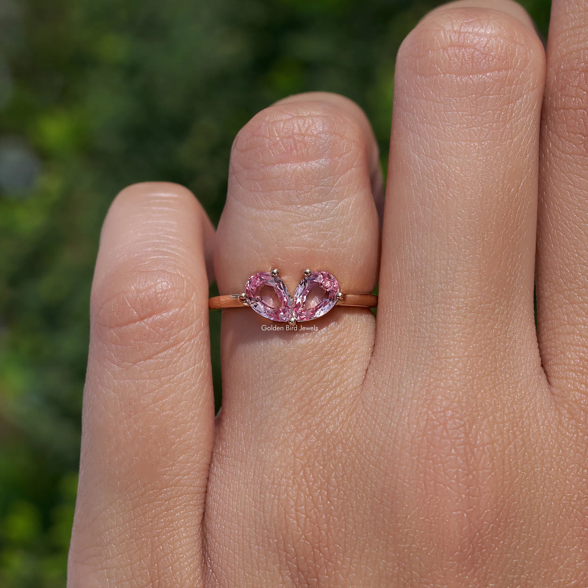 Pink pear-cut lab gemstone toi et moi ring with two stones on a slim metal band