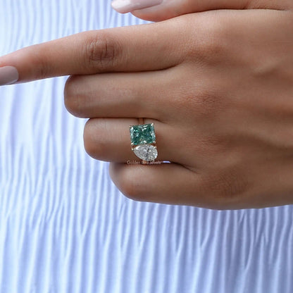 Silver ring with a single green radiant-cut gemstone in a prong setting