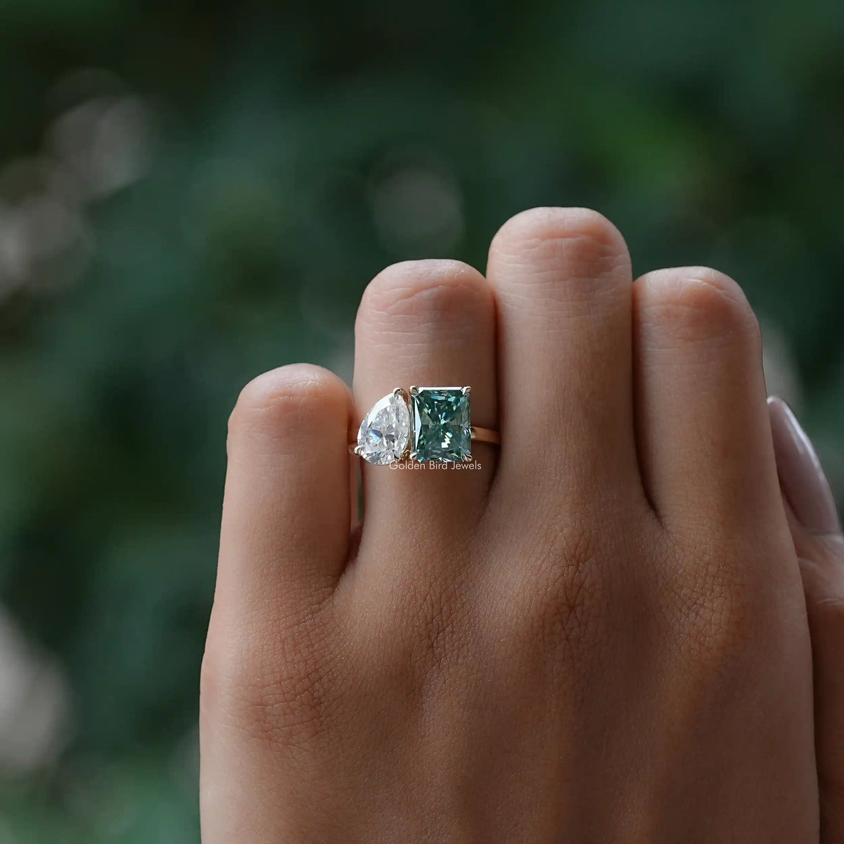Silver toi et moi ring with green radiant center and clear pear side gemstone