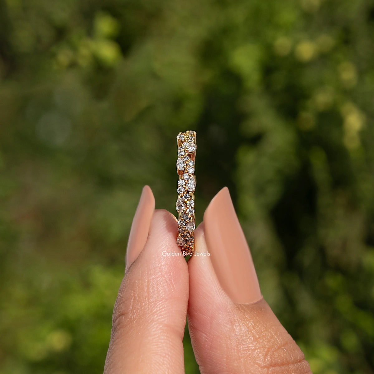 Vertical view of moissanite eternity band with pear-and-round stones