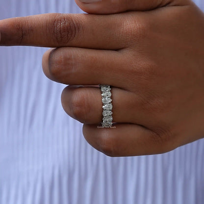 Silver eternity band ring with row of prong-set sparkling stones, side view