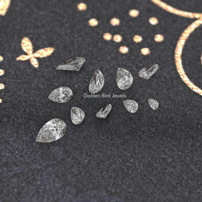 Loose pear-shaped lab-grown diamonds on dark display with multiple stones