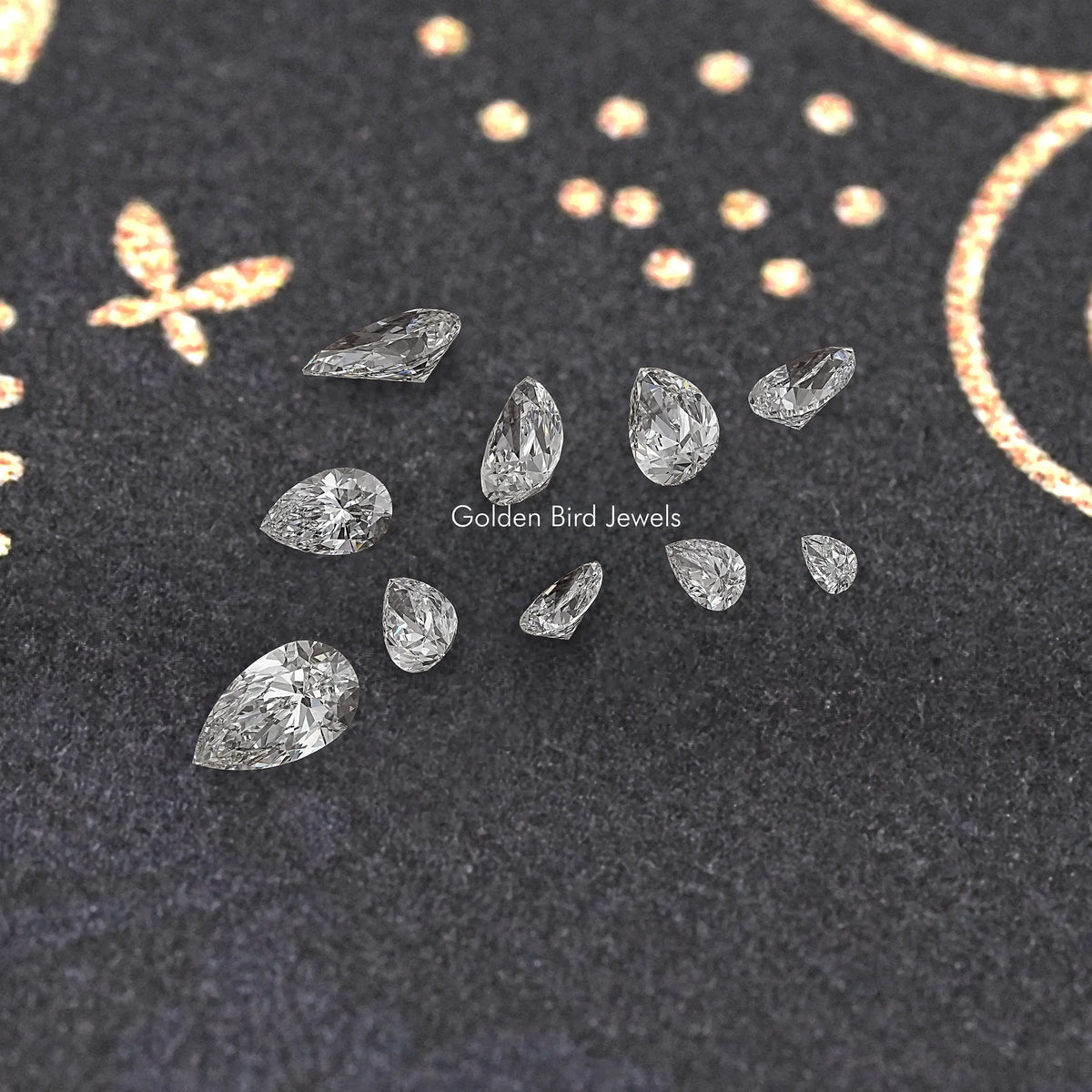 Assorted pear-cut lab diamonds on dark fabric, multiple sizes with polished facets.