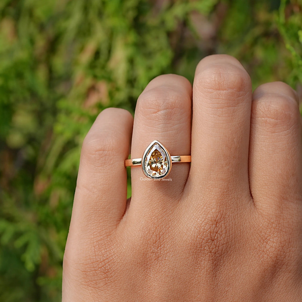 In finger front view of Yellow Moissanite Bezel Set Solitaire Ring  
