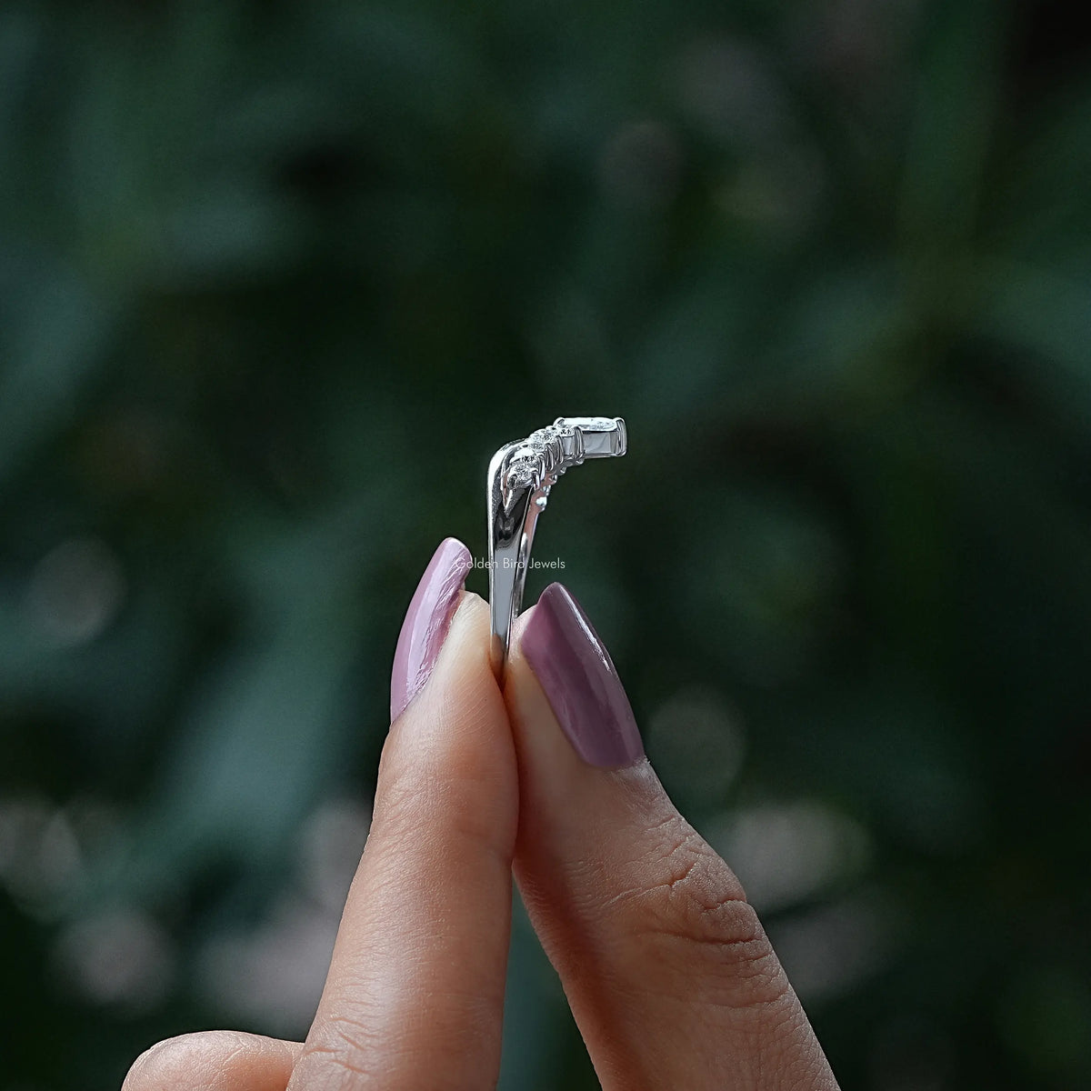 Silver chevron wedding band with pear-shaped stones, angled side view