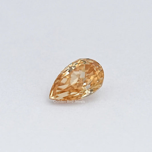 Pear-cut moissanite loose stone, golden champagne color, angled facet view