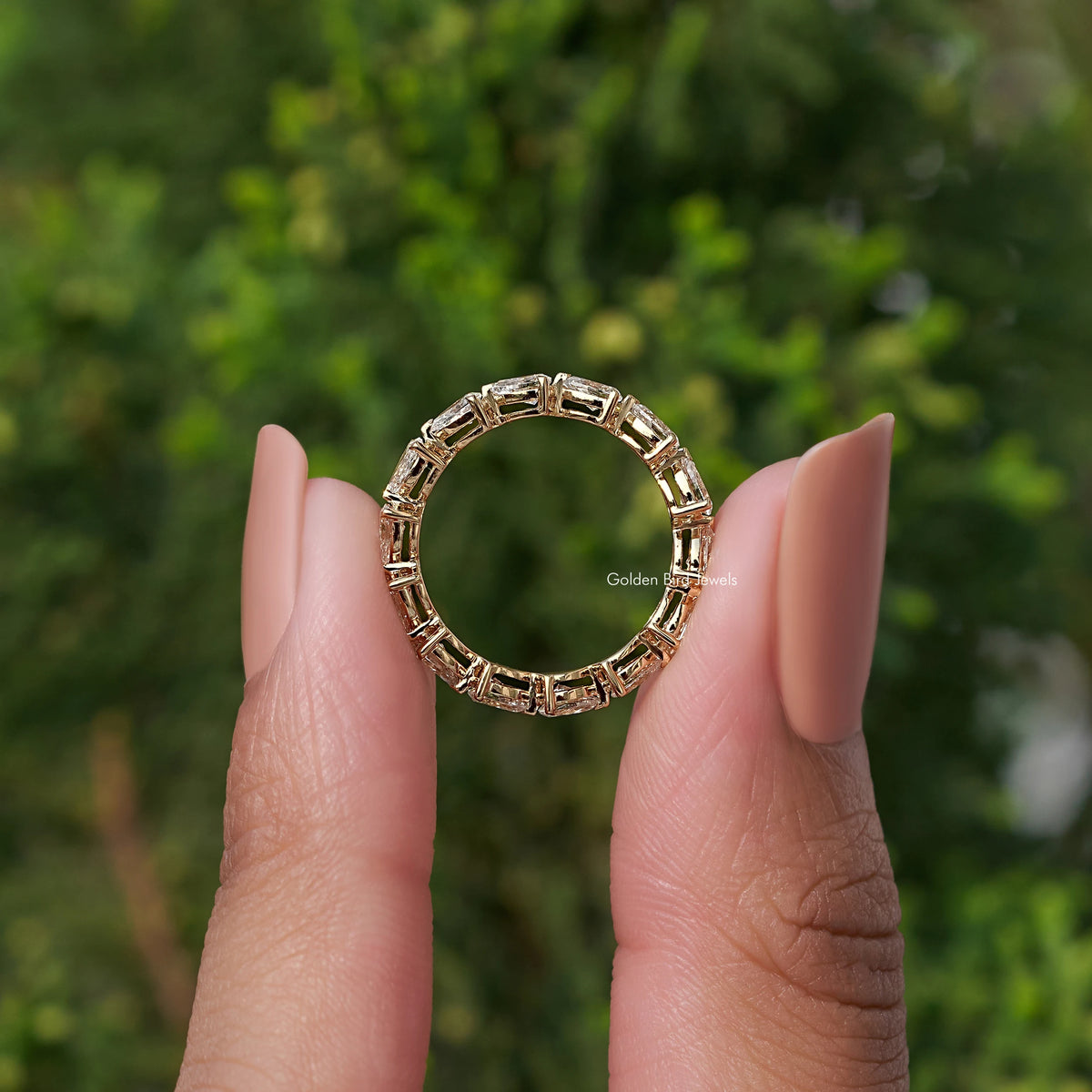 Circular view of eternity band ring with rectangular-cut stones in gold