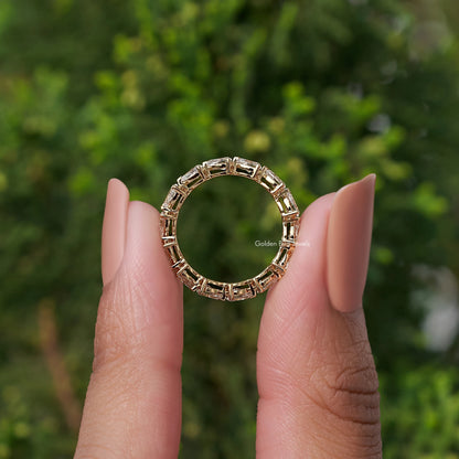 Circular view of eternity band ring with rectangular-cut stones in gold