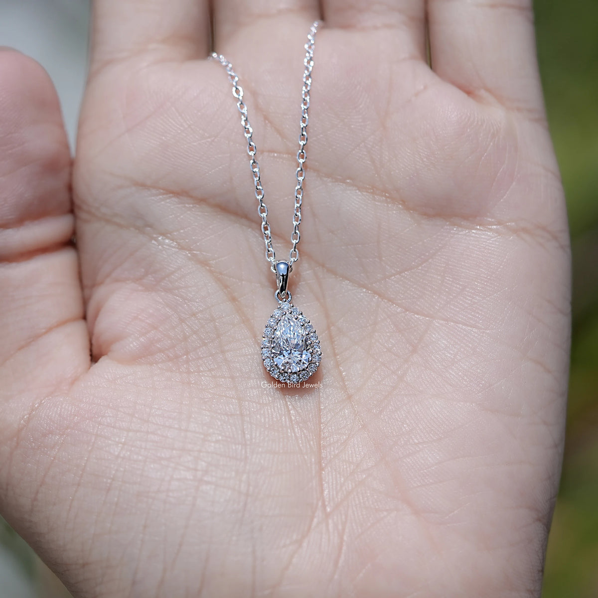 In Hand Showing of Lab Grown Pear Cut Halo Pendant
