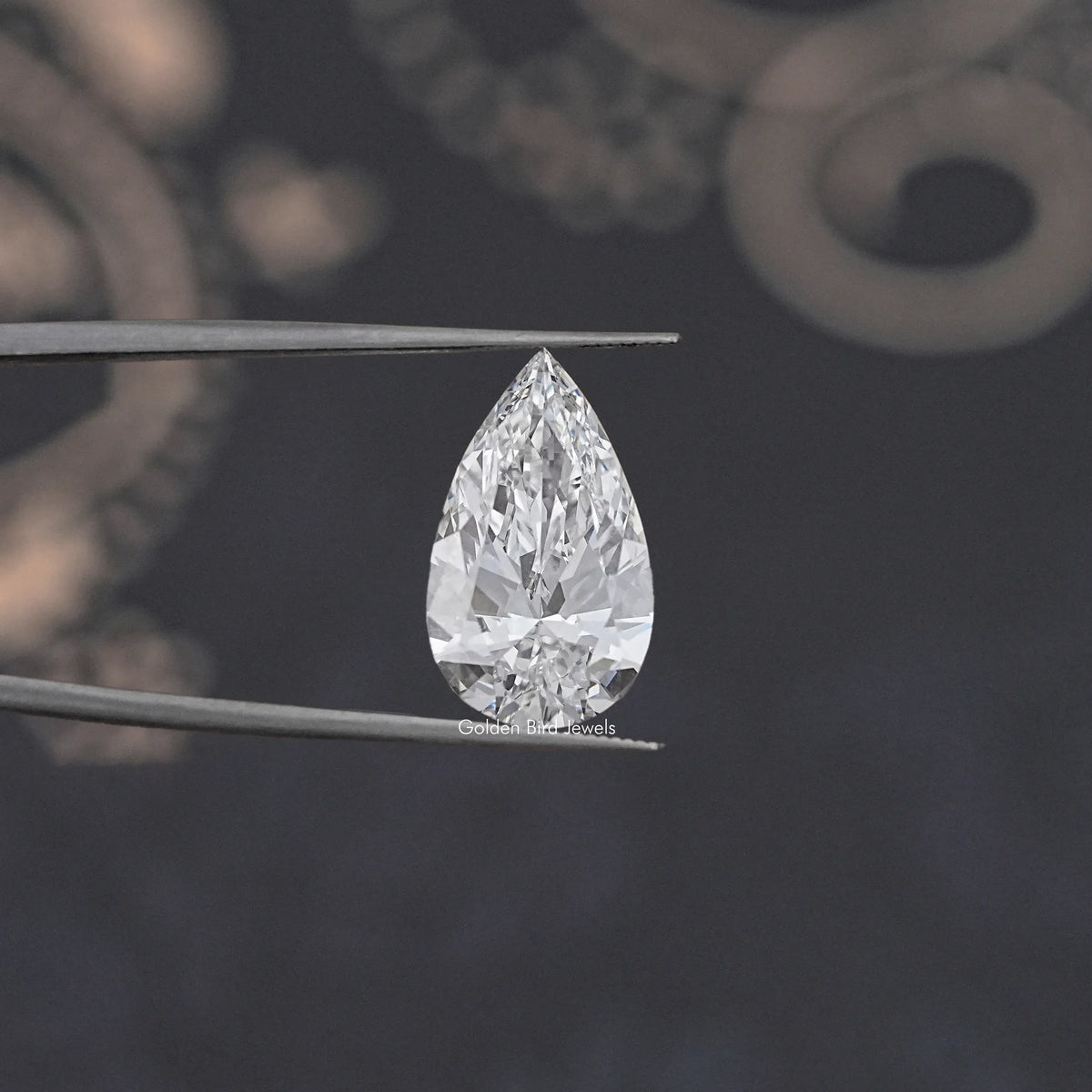 Loose pear-cut lab diamond, clear white, held by tweezers; faceted teardrop