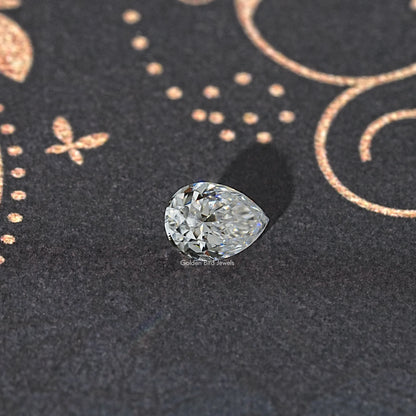 Near colorless pear-cut moissanite loose gemstone on dark background