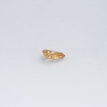 Pear-cut moissanite loose stone, golden champagne tone, horizontal facet view