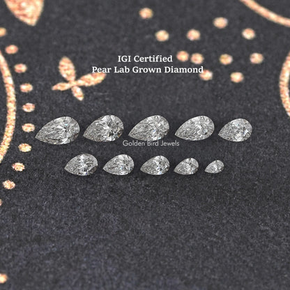 Multiple pear-shaped lab-grown diamonds arranged on dark velvet