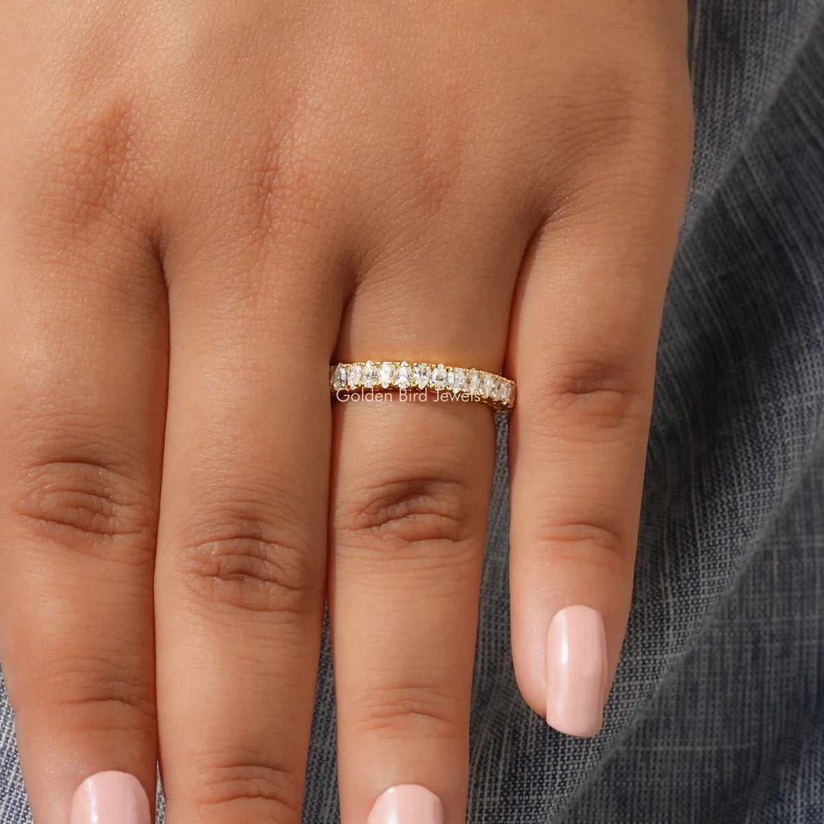 Pear-shaped moissanite half eternity stacking band on a finger