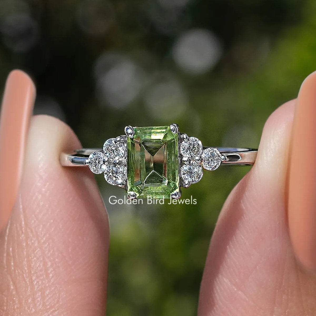 Emerald-cut green gemstone engagement ring with diamond halo and silver band