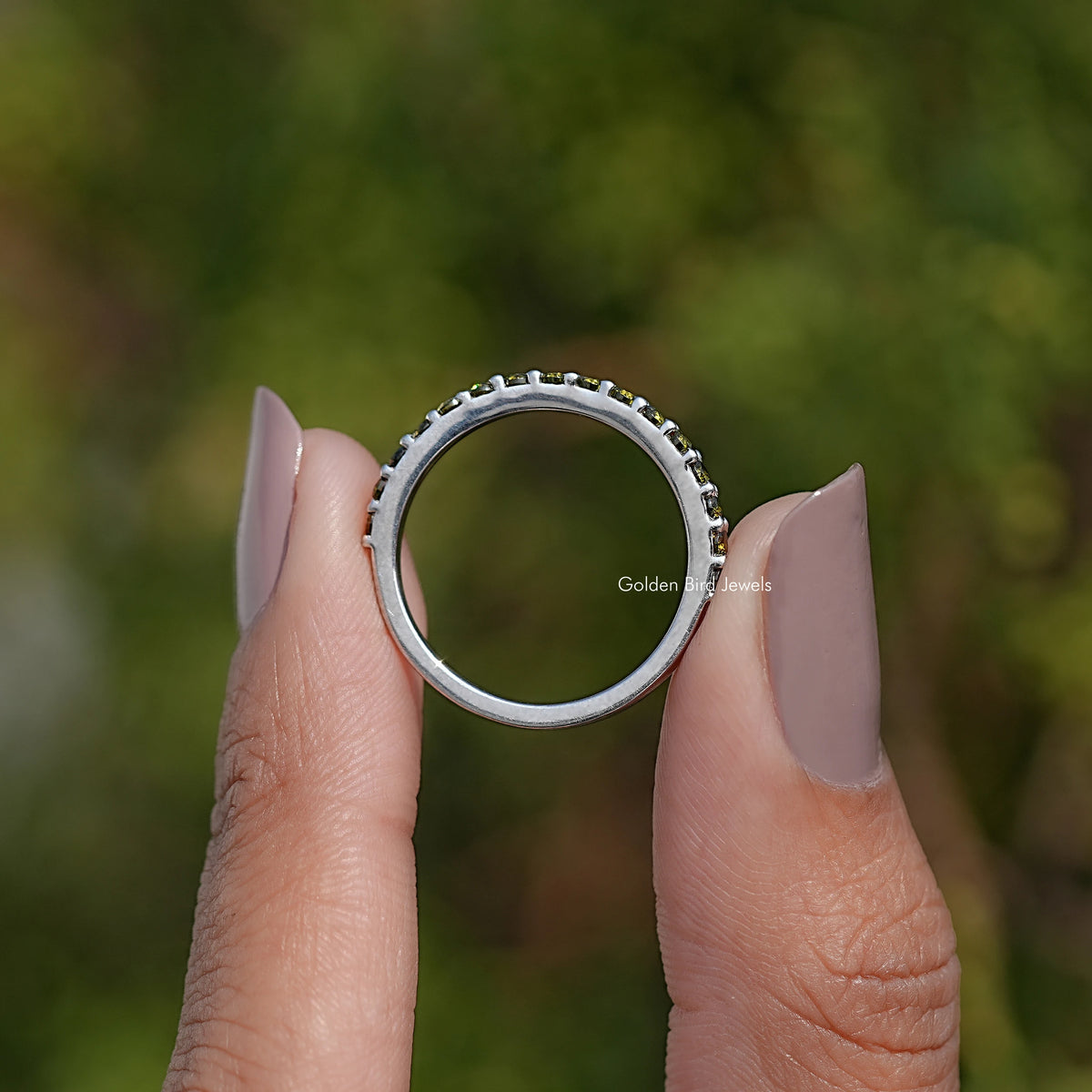 Round-stone eternity band ring with green peridot-like stones on metal band