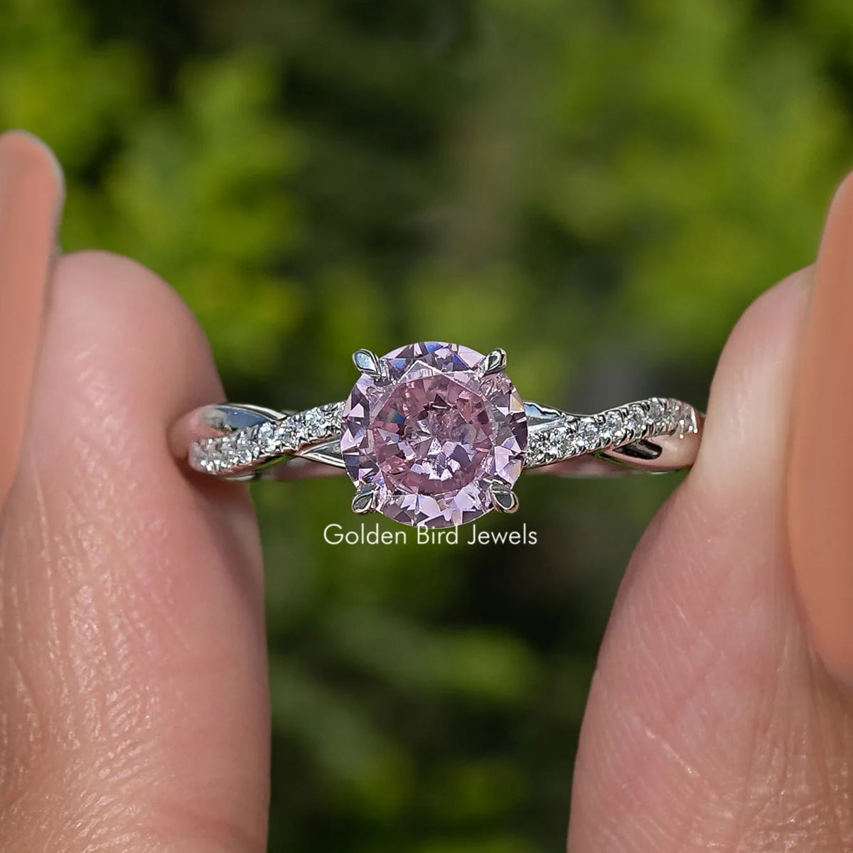 Sterling silver ring with round pink gemstone and small side accent stones