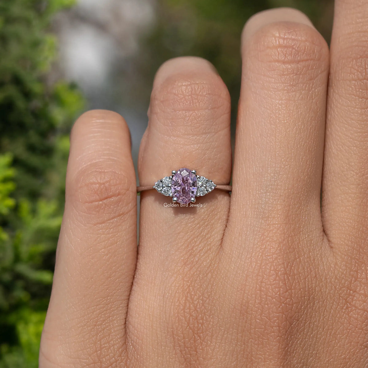 Silver ring with oval pink gemstone and small round side accents