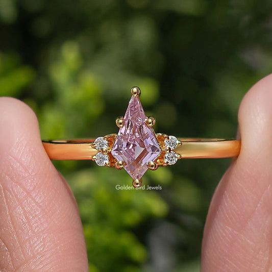 Gold ring with pink kite-cut center gemstone and round side diamonds