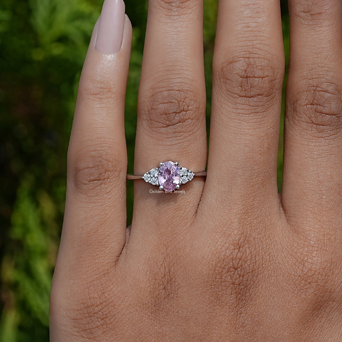 Silver engagement ring with oval pink center stone and round side stones