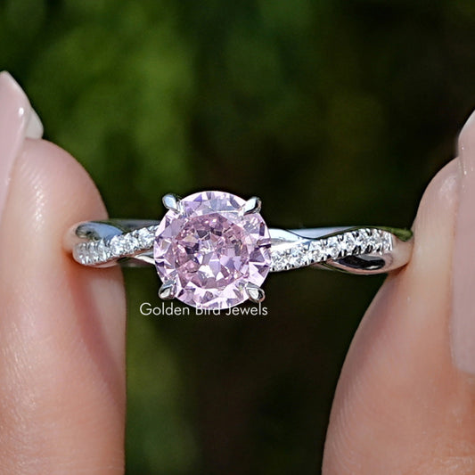Close-up of sterling silver ring with large pink round gemstone and side stones