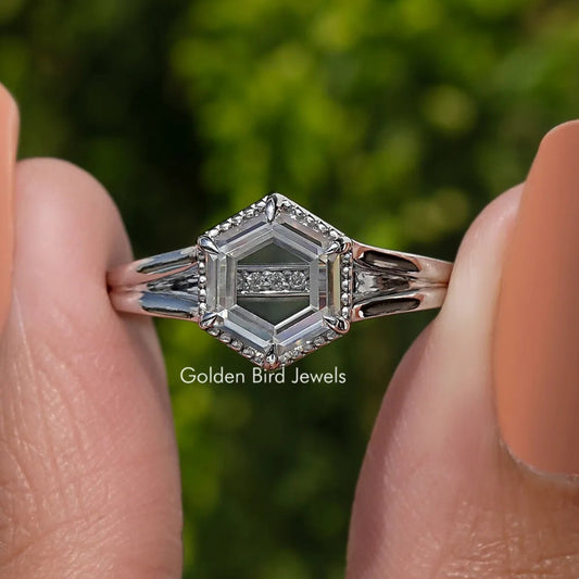 Hexagon-cut moissanite ring close-up, faceted center stone with side accent stones