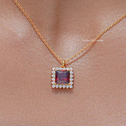 Square ruby-red gemstone pendant with clear stone halo on gold chain