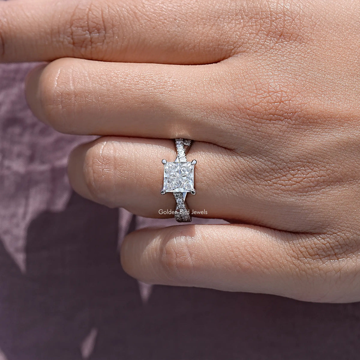 Angled view of sterling silver engagement ring with princess-cut moissanite center stone