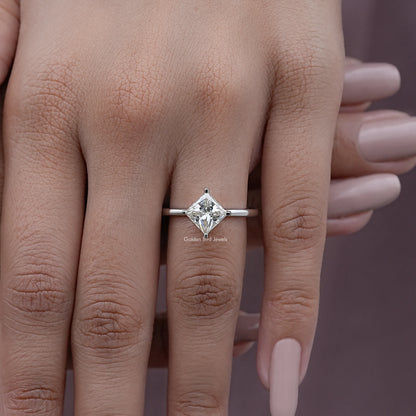 Princess-cut solitaire engagement ring on hand, clear square center stone and slim silver band
