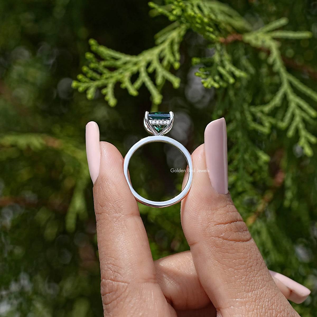 925 sterling silver wedding ring showing open hidden halo setting around emerald-green stone