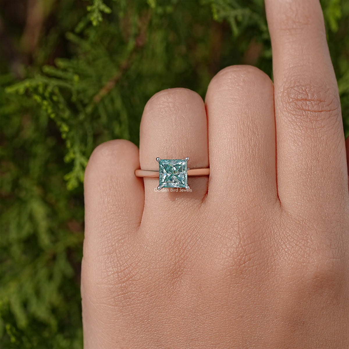 Silver band moissanite solitaire ring with square light-blue princess-cut center stone