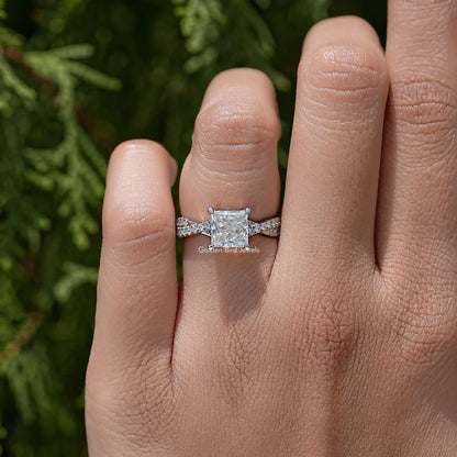 Sterling silver ring on finger featuring princess-cut moissanite and twisted shoulders