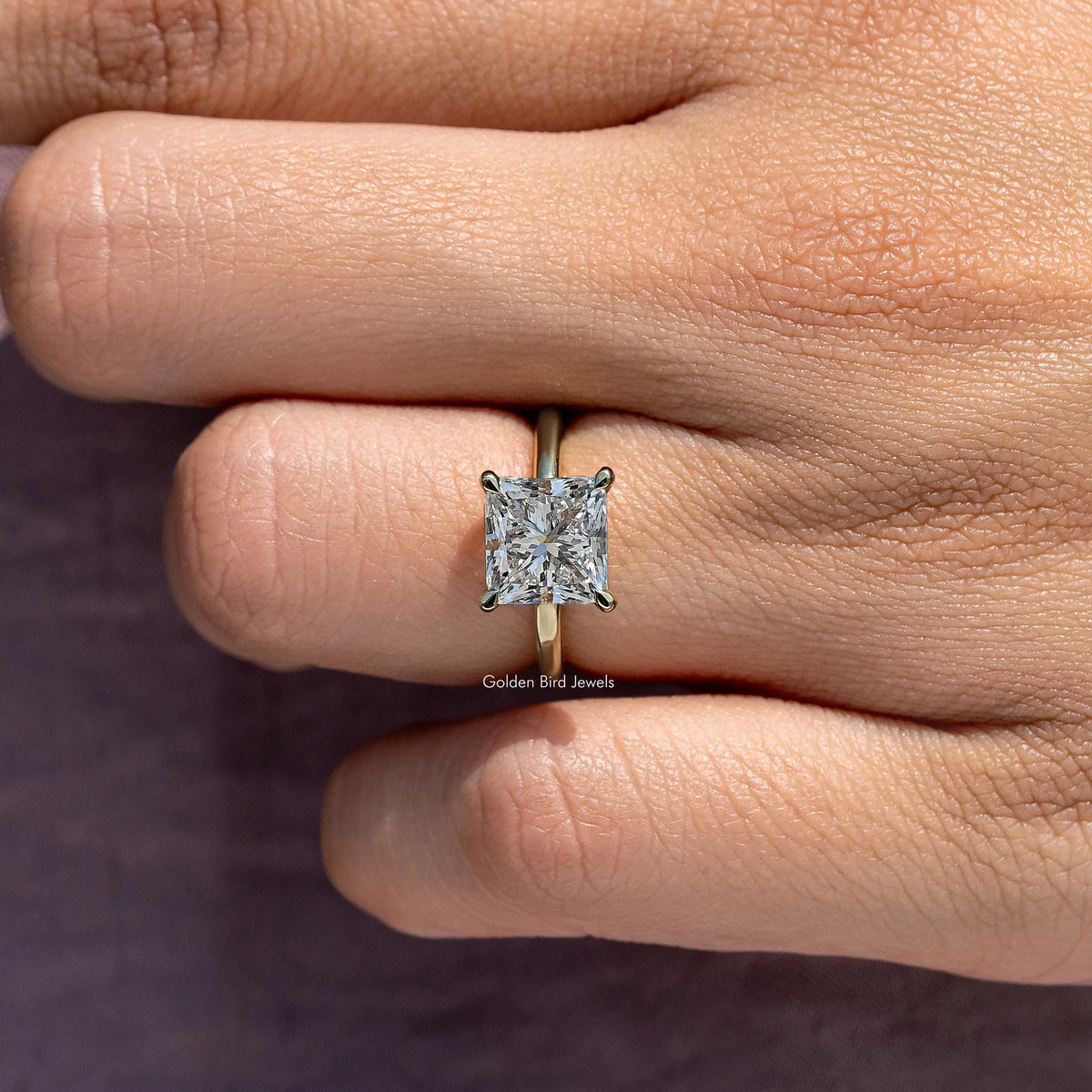 Princess-cut diamond solitaire ring close-up on center stone and prongs