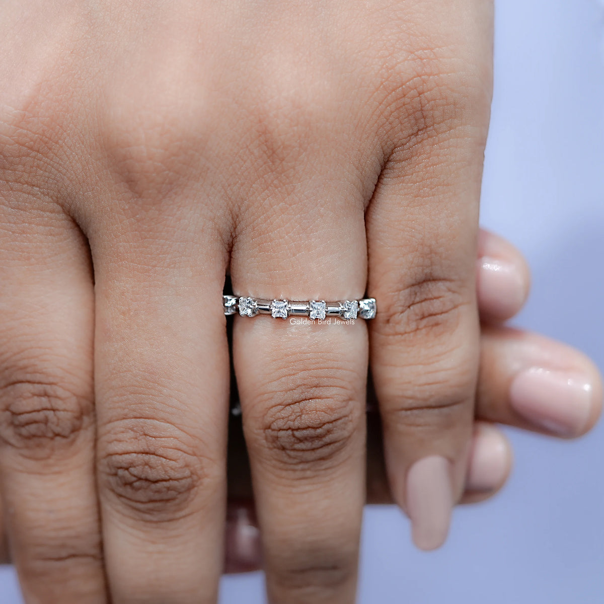 Princess-cut moissanite half eternity band on finger, close-up front
